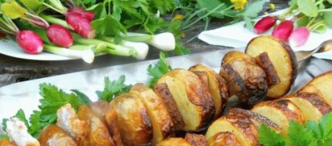 Potato skewers with lard on the grill on skewers Potatoes baked on charcoal on skewers recipe