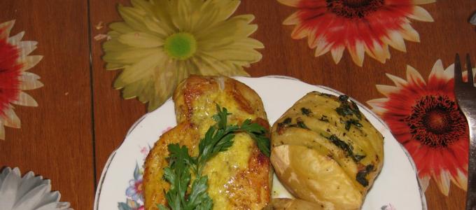 Baked potatoes in the oven with chicken and cheese